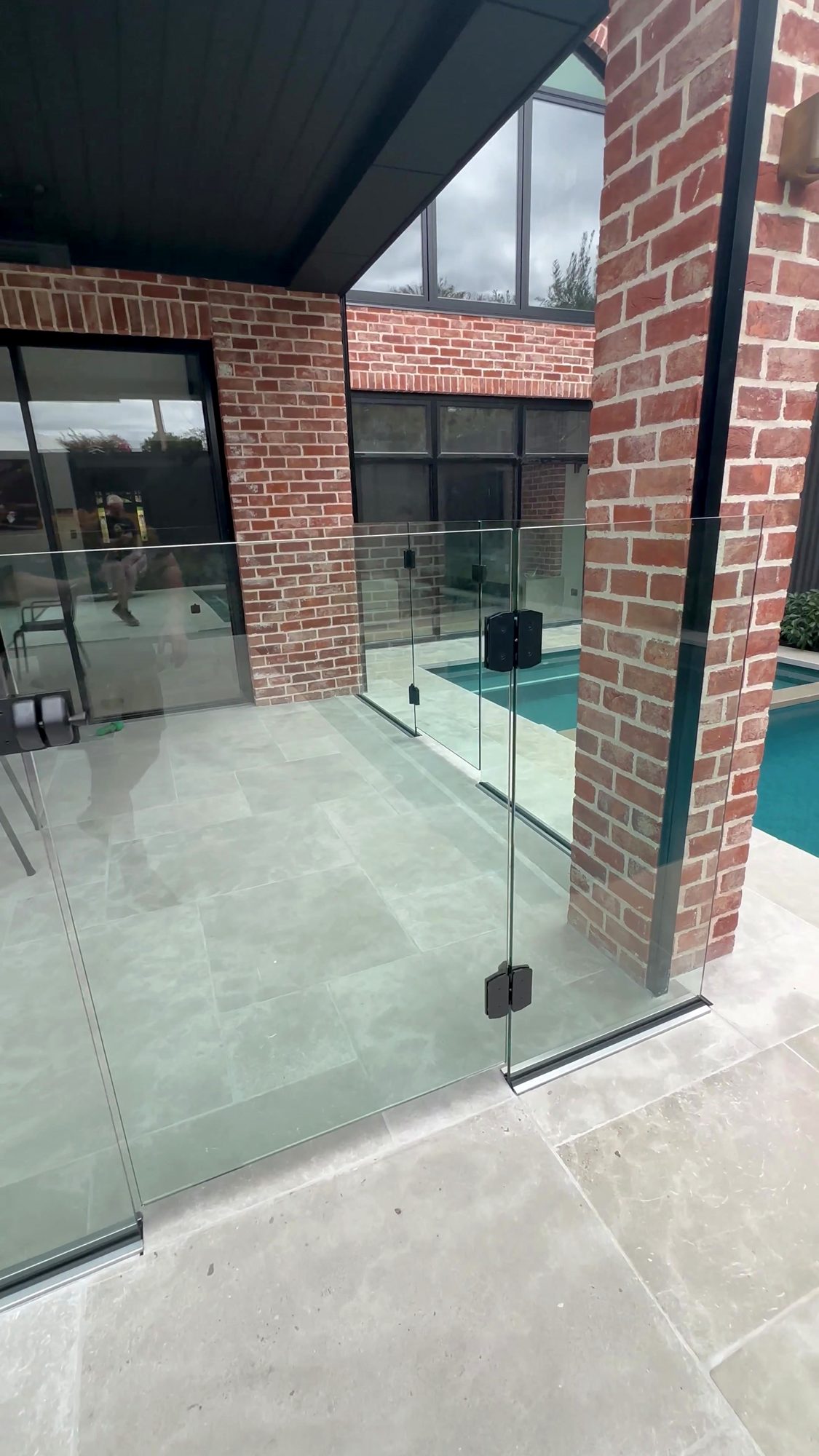 Frameless glass pool gate beside brick alfresco columns, Adelaide — Unique Glass Solutions
