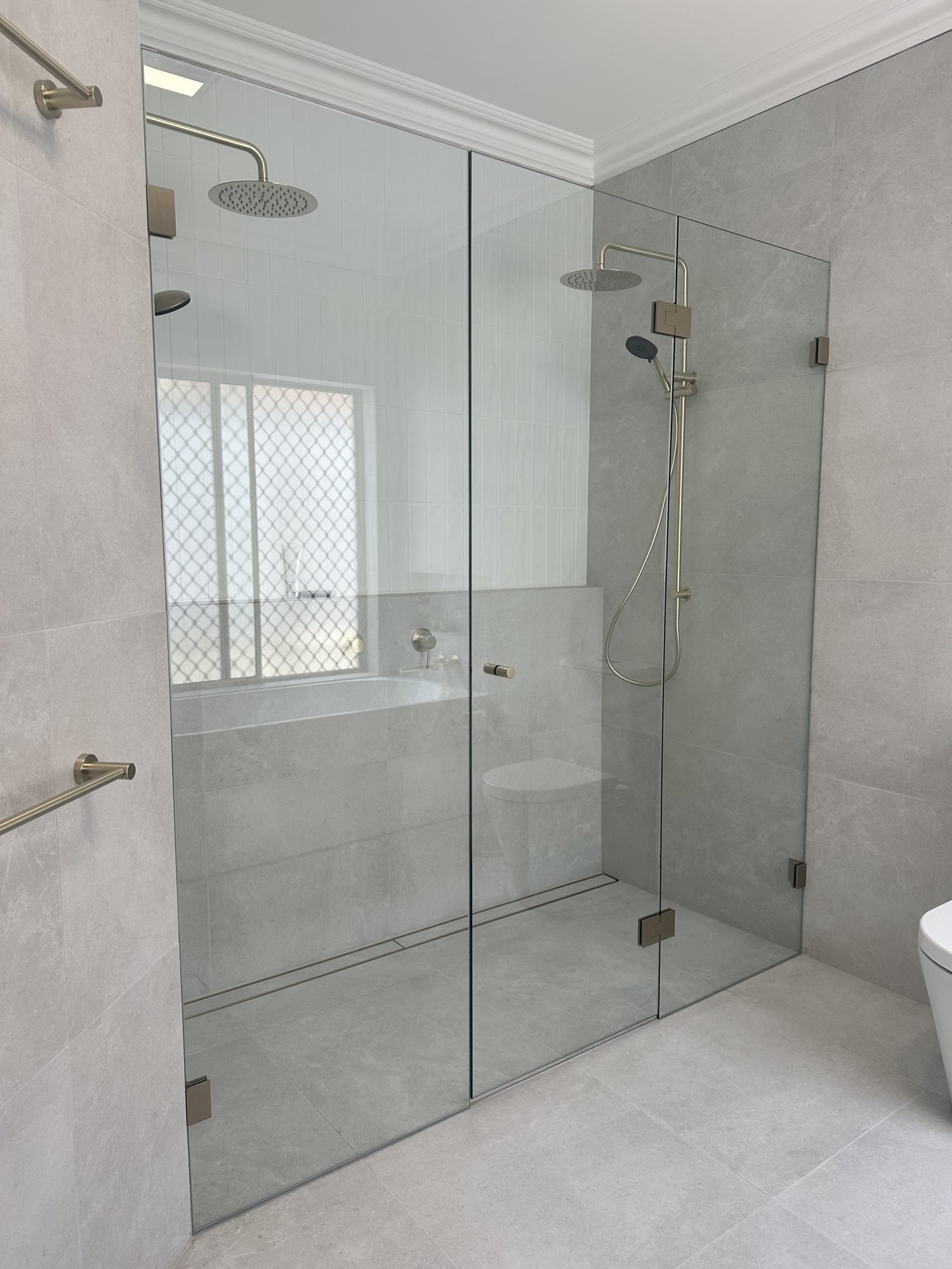 Twin frameless shower with Elevated brushed-bronze hardware, Adelaide